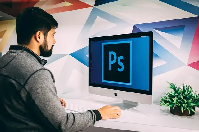 hombre frente a PC editando fotos con Adobe Express